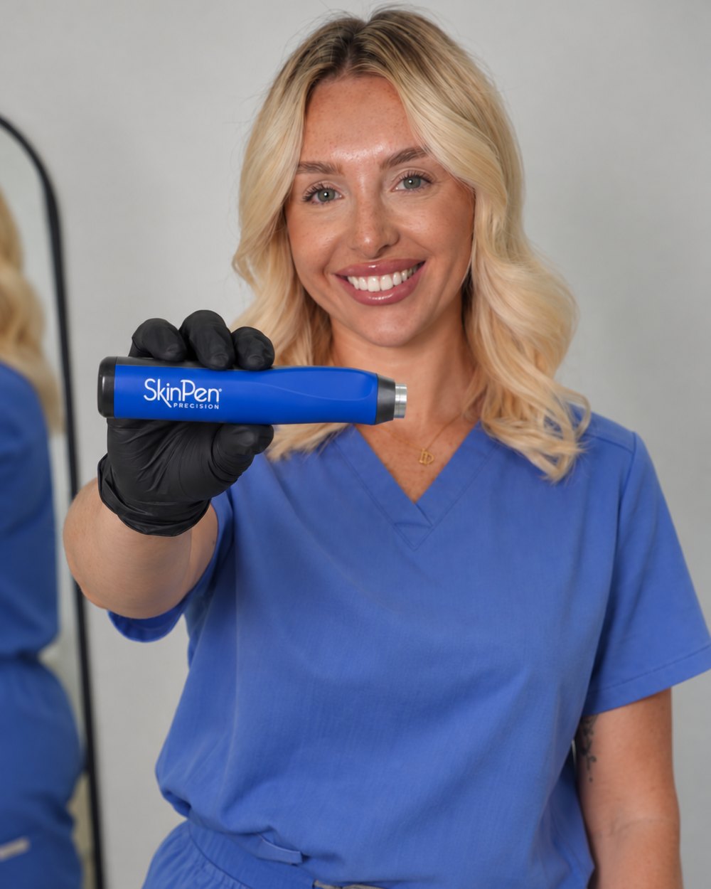 Becci, NMC registered nurse at The Face Lab, holding the SkinPen Precision microneedling device
